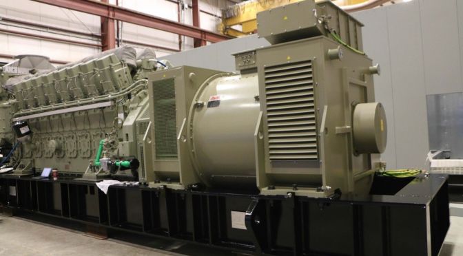 Large industrial generator on display inside a facility, highlighting its complex structure and mechanical components used in heavy-duty power generation.