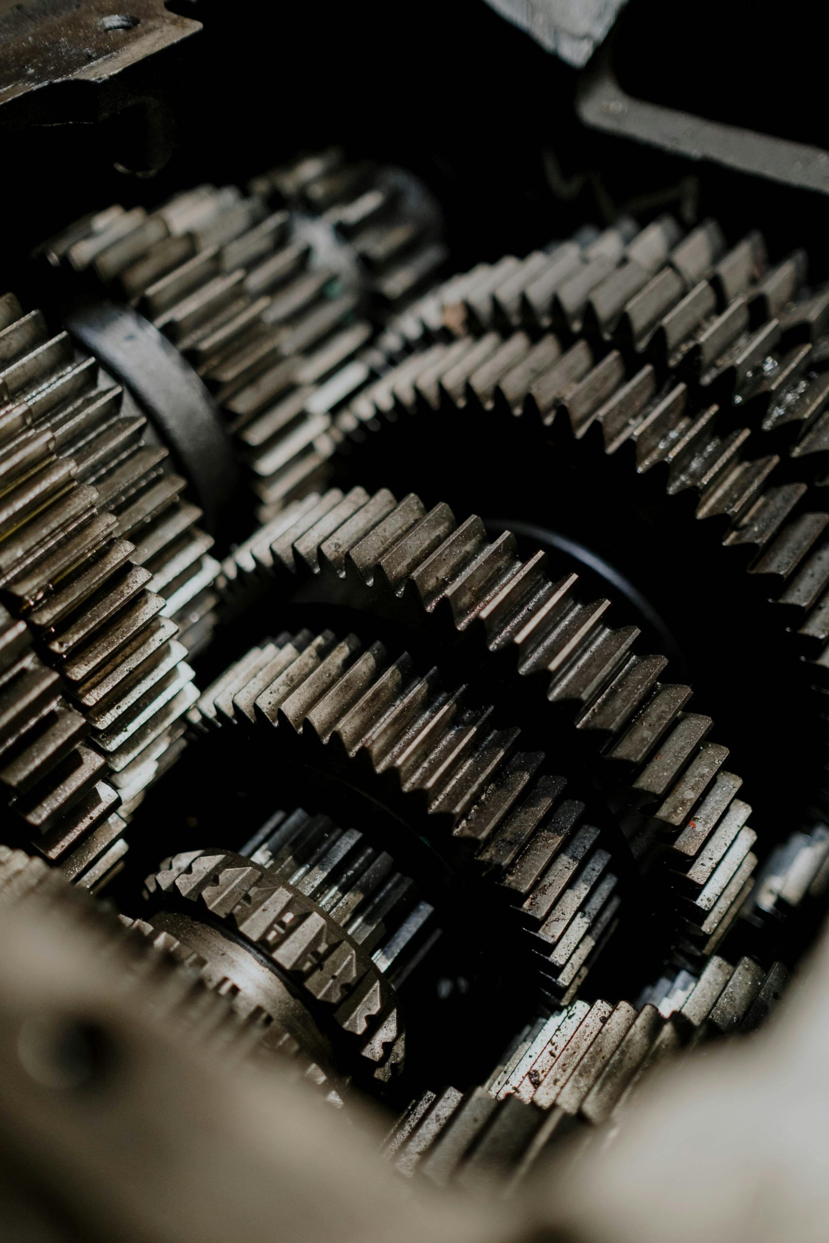 Close-up of intricate machine gears showing detailed tooth profiles and signs of wear, illustrating complex mechanical engineering and maintenance needs.